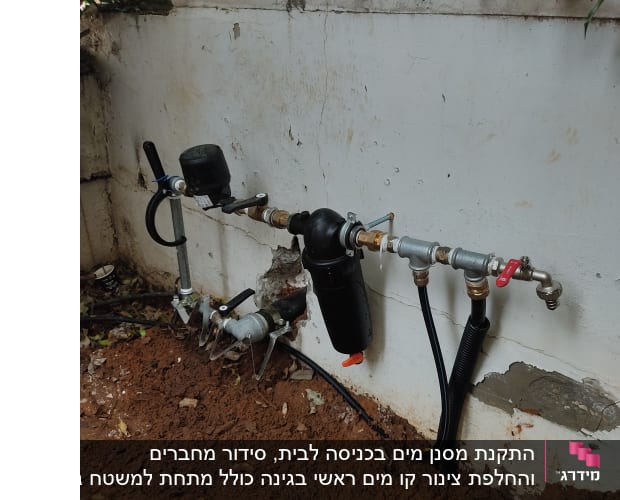 צנרת מים עם ברזים ומסנן על קיר חיצוני